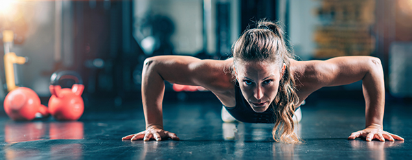 Woman Doing Push-ups in the gym. Strength Training.